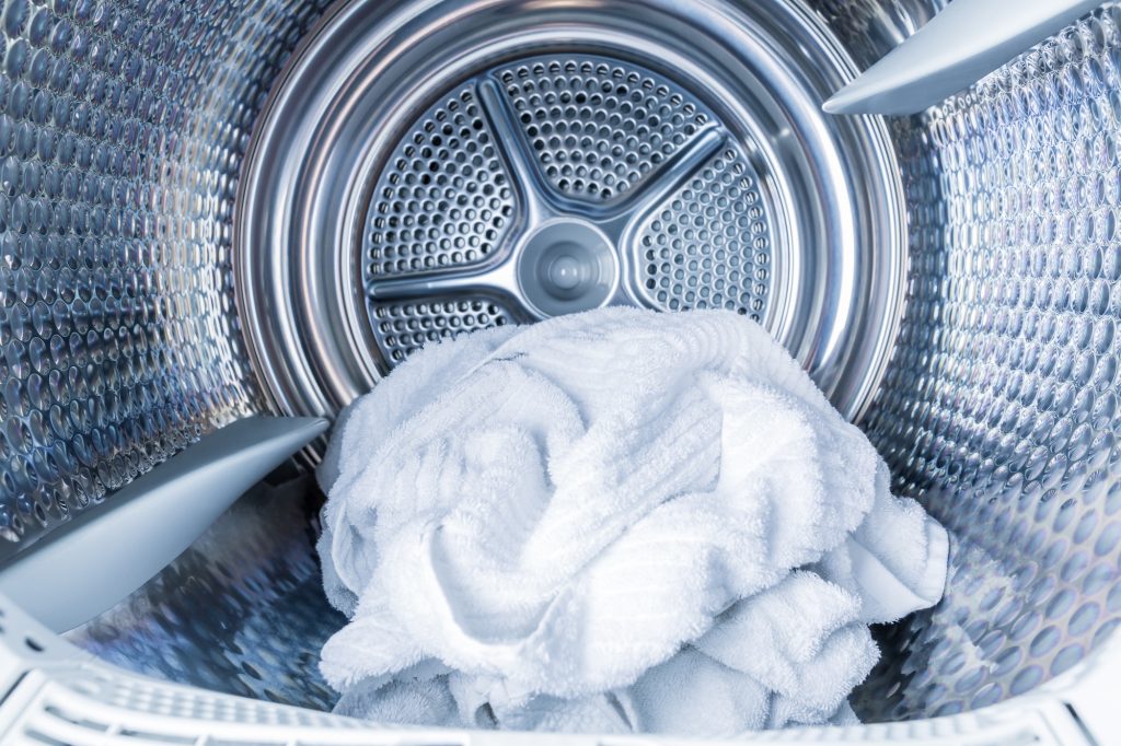 Inside of tumble dryer with clean white towels - new generation of dryer